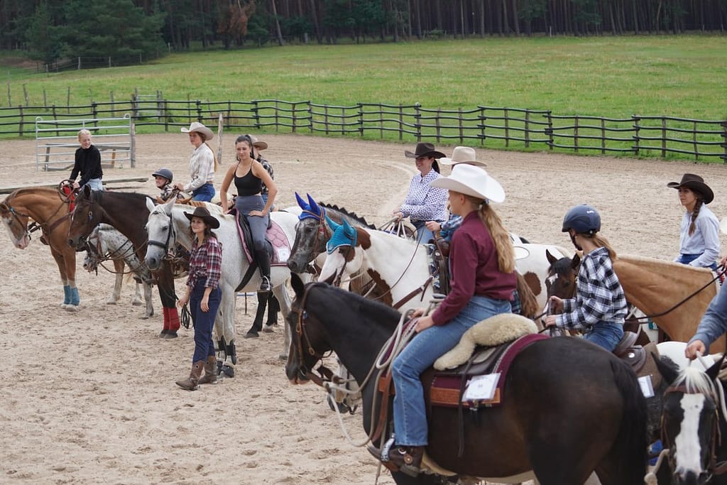 Western-Reitkurs Line-up im Roundpen, Reiter auf verschiedenen Pferden aufgereiht, Kurs-Setting der Six Tower Ranch